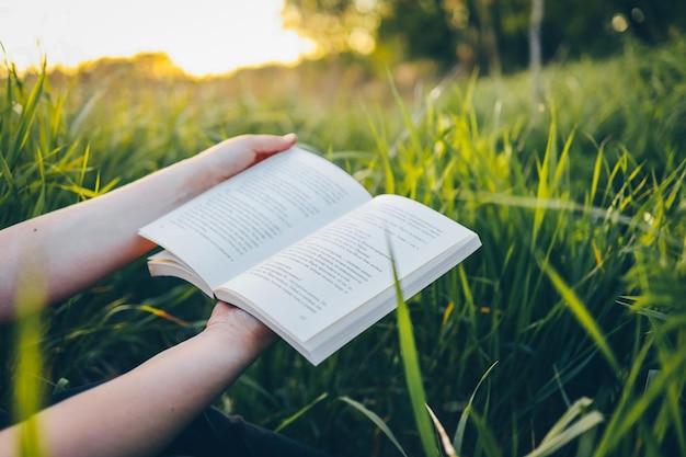 Um livro aberto nas mãos o conceito de natureza tranquilidade e solidão