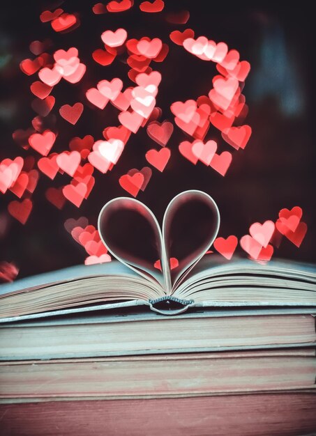 Um livro de papel em forma de coração contra um fundo de bokeh NA FORMA DE CORAÇÕES Valentine