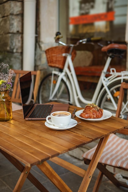 Um local de trabalho freelancer39 em um café com um croissant e café