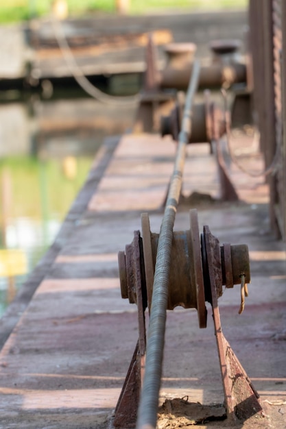 Um longo cabo de metal correndo ao longo da travessia de balsa Antigo poste de amarração vintage enferrujado para barcos navios e iates Sistema de controle para a balsa