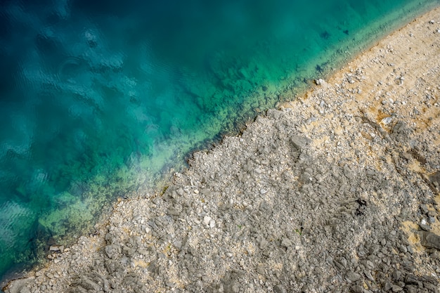 Um lugar pitoresco onde a água azul-turquesa transparente encontra uma costa pedregosa.