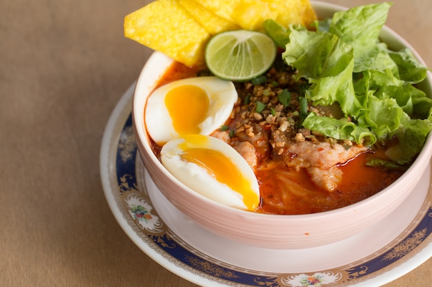 Um macarrão com sopa picante. Macarrão plano temperado temperado com carne de porco e ovo cozido