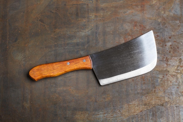 Um machado de cozinha em uma mesa de metal em uma vista superior