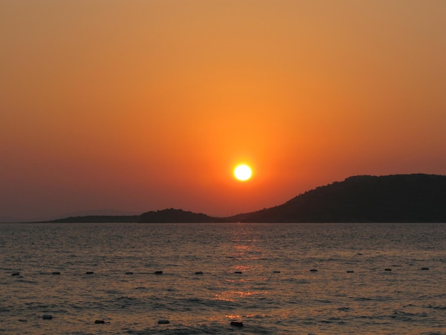 Um mar calmo com um céu pôr do sol e o sol através das nuvens Oceano e céu para meditação Paisagem marinha calma O horizonte está acima da água