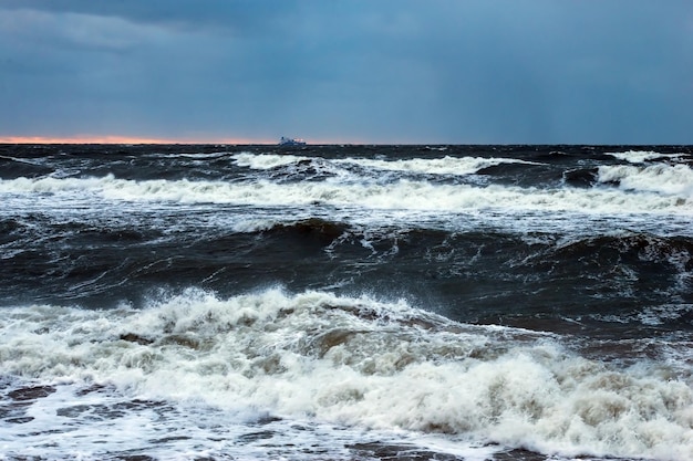 Um mar tempestuoso com um navio ao fundo