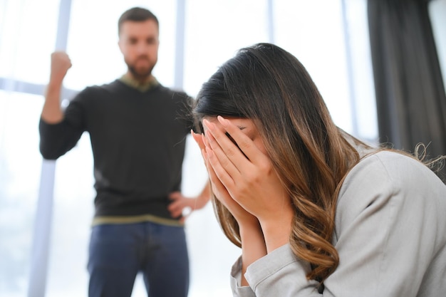 Foto um marido agitado e chateado grita e olha para sua esposa uma briga entre os cônjuges disputa de mal-entendimento familiar