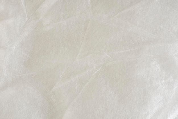 Um material de poliéster sintético branco usado como isolamento em roupas ou como textura de material de embalagem
