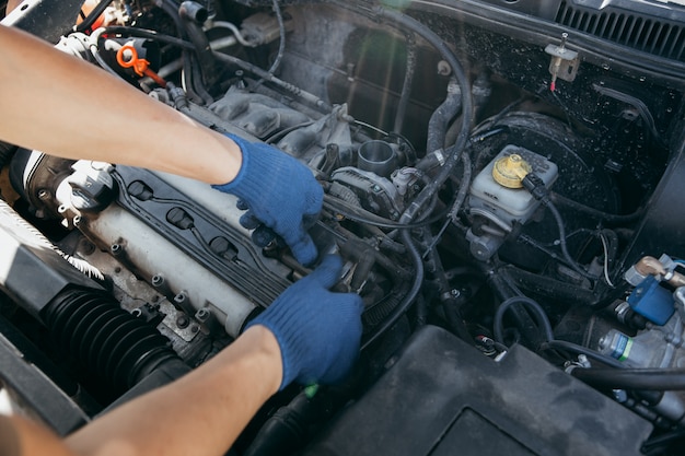 Um mecânico de automóveis reparando um motor de carro