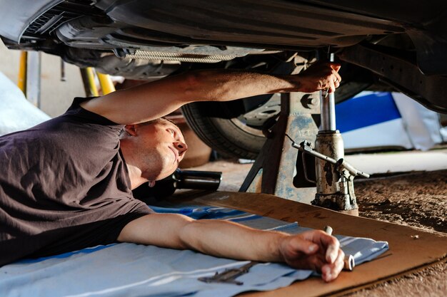 Um mecânico de automóveis trabalha em uma garagem. reparo de carro