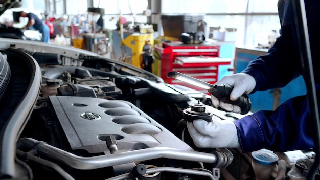 Foto um mecânico trabalhando em um motor de veículo em uma oficina