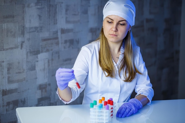 Um médico assistente de laboratório profissional médico realiza uma análise em um laboratório usa tubos de ensaio uma pipeta e uma placa de Petri para a presença de bactérias no corpo humano Foco seletivo