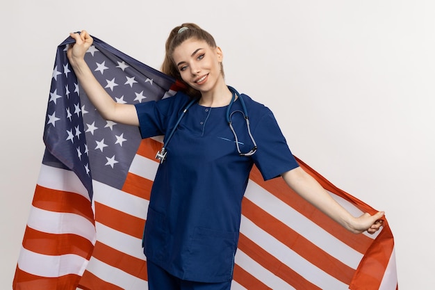 Um médico de família em um fundo branco com as estrelas e listras dos Estados Unidos ao fundo