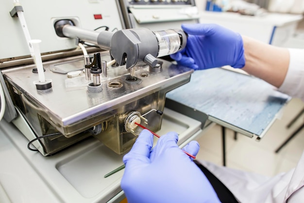 Um médico em luvas azuis processa exames de sangue médicos para oxigênio em equipamentos de medição
