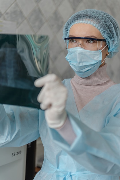 Um médico está examinando uma radiografia de um paciente com coronavírus.