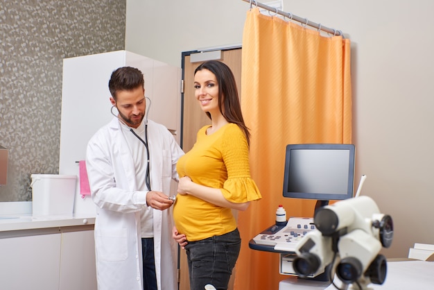 Foto um médico examinando uma mulher grávida