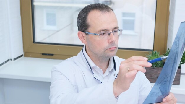 Foto um médico olha para os resultados de uma tomografia computadorizada do cérebro