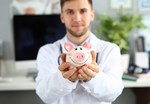 Um médico sorridente com uma caixa de poupança.