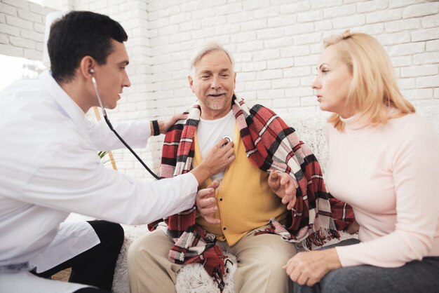 Um médico veio ao velho em um cardigã amarelo.