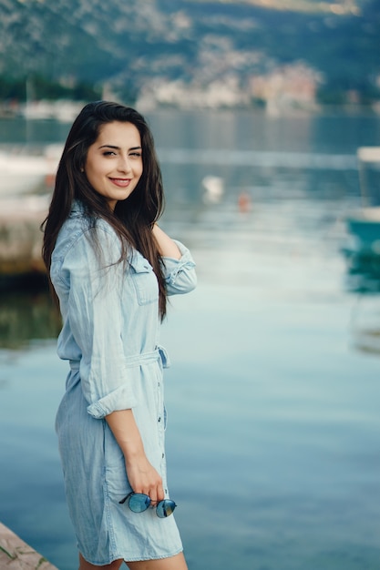 Um, menina jovem bonita, em, um, vestido azul, ficar, perto, água