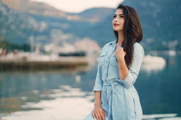 Um, menina jovem bonita, em, um, vestido azul, ficar, perto, água