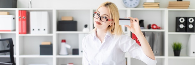 Um, menina jovem, inclinado, escrivaninha, em, escritório, e, segurando, um cartão banco