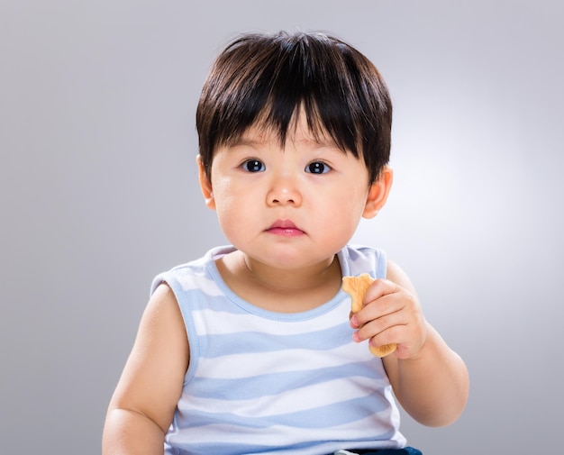 Um menino a comer com os dedos.