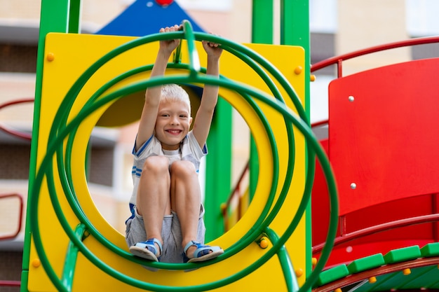 Um menino alegre no parquinho em um dia de verão