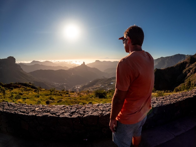 Um menino ao pôr-do-sol perto de Roque Nublo, em Gran Canária, Ilhas Canárias