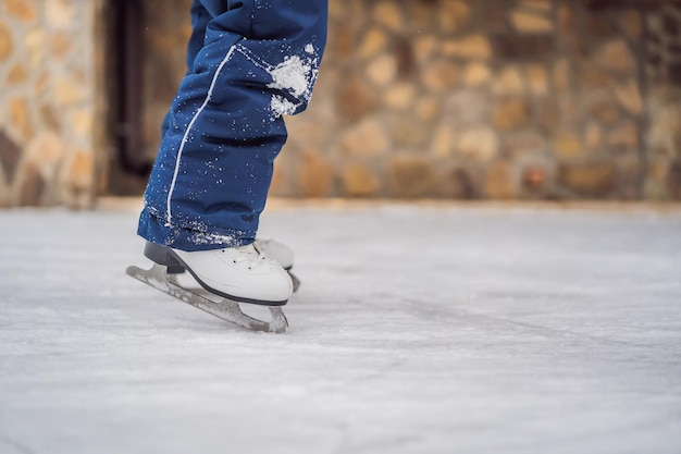 Um menino aprendendo a patinar no gelo