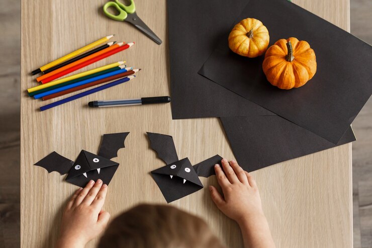 Foto um menino bonitinho fez um bastão de halloween de papel preto. trabalho manual das crianças.