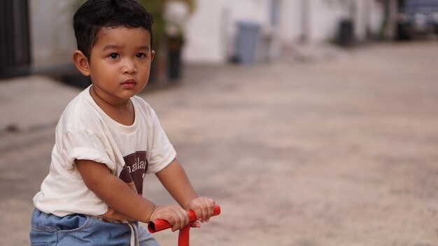 Foto um menino bonito a brincar com um brinquedo em terra.