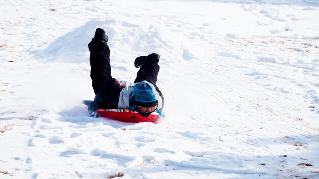 Um menino brincando na neve.