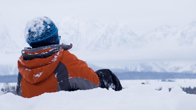 Um menino brincando na neve.