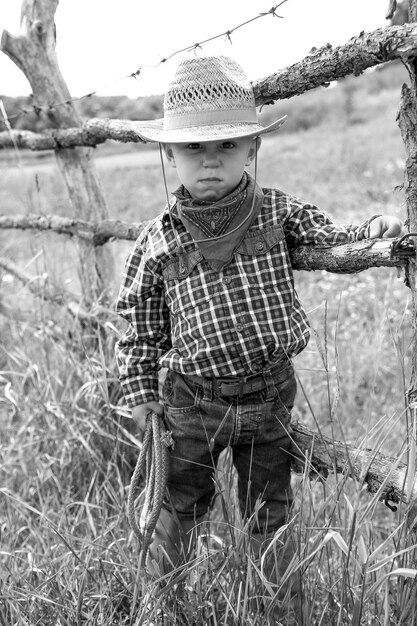 Um menino com chapéu de cowboy na natureza