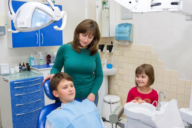 Um menino com sua família no dentista na clínica
