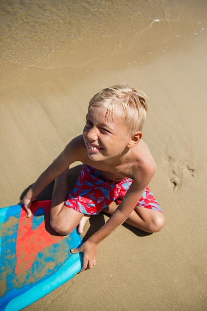 Um menino com um bodyboard em uma onda