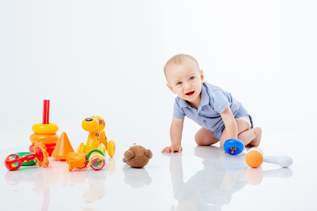 Um menino com uma pirâmide multicolorida é isolado em um fundo branco;