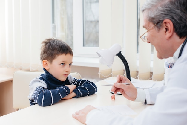 Um menino consultado por um médico na clínica