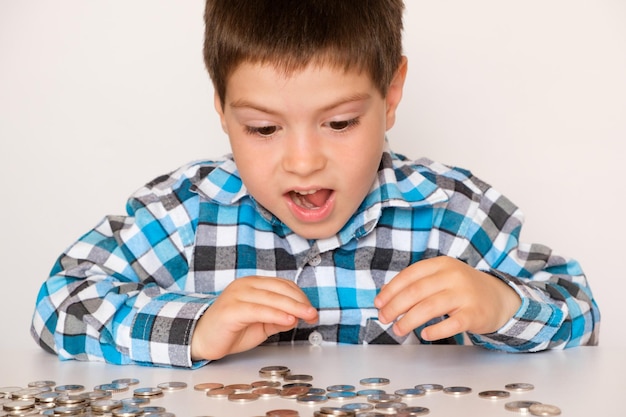 Um menino de 4 anos conta moedas se alegra abrindo a boca