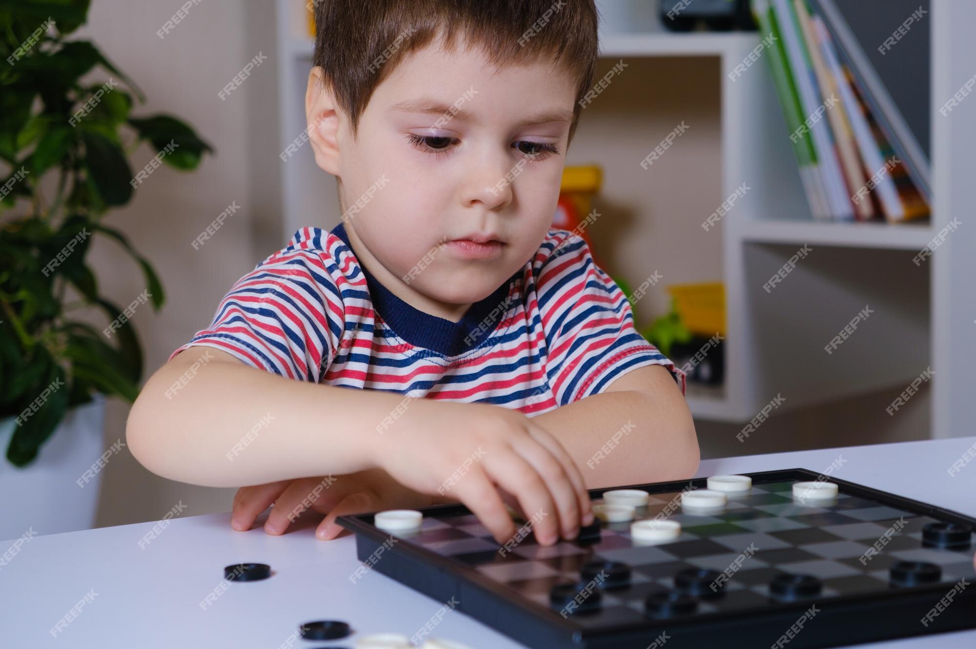 Um menino de 4 anos joga um jogo de damas