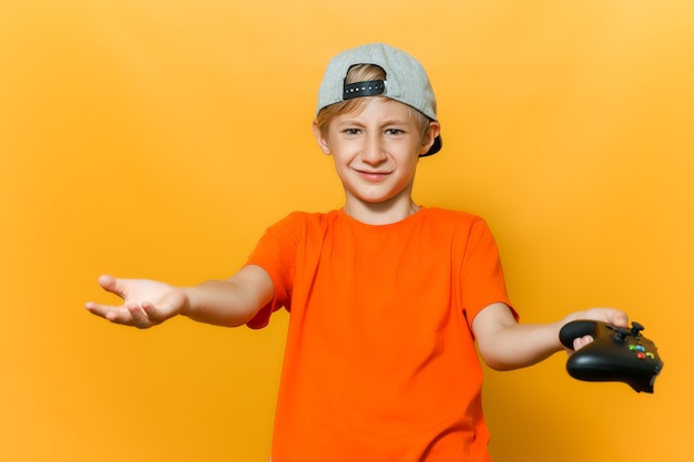 Um menino de boné e camiseta laranja abriu as mãos em diferentes direções; ele segura um gamepad em uma das mãos