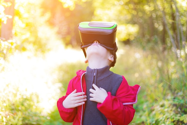 Foto um menino de óculos de realidade virtual na rua crianças modernas tecnologias modernas