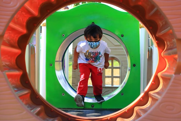 Foto um menino de pé no playground.