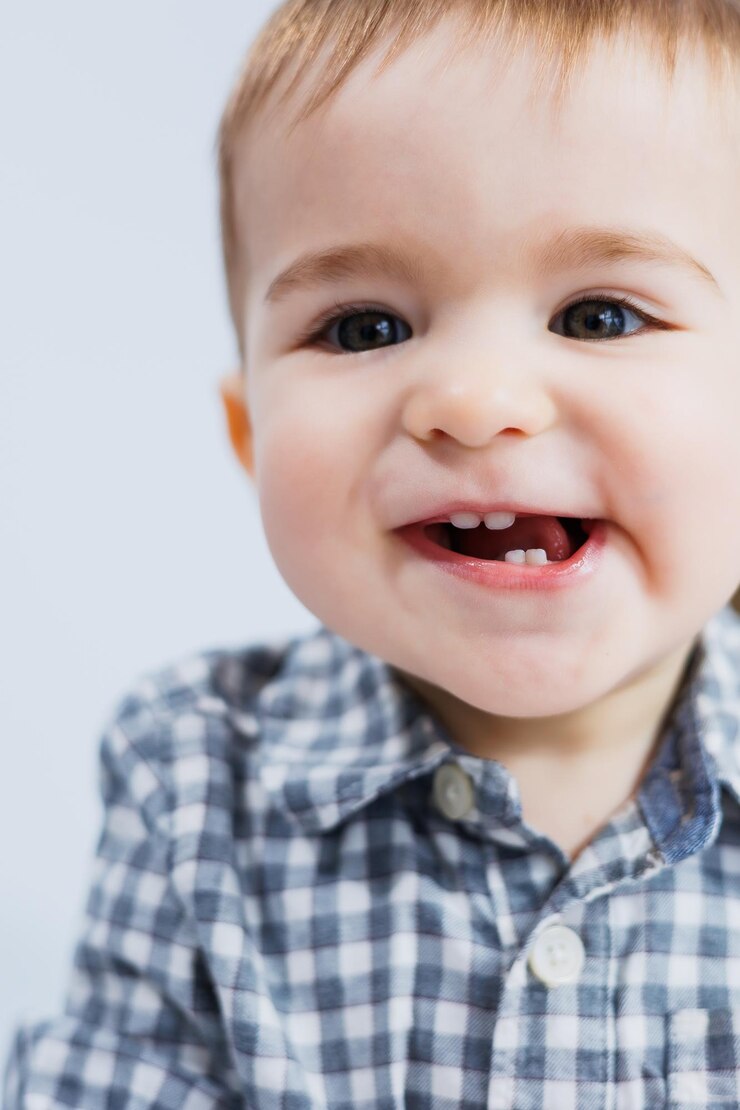 Um menino de um ano de idade em um fundo branco em uma camisa xadrez Uma criança pequena com um sorriso no rosto