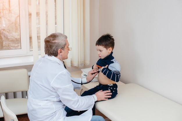 Um menino é ouvido e tratado por um médico experiente em uma clínica moderna. um vírus e uma epidemia.