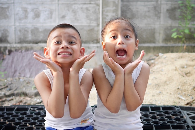 Um menino e uma menina estão sorrindo.