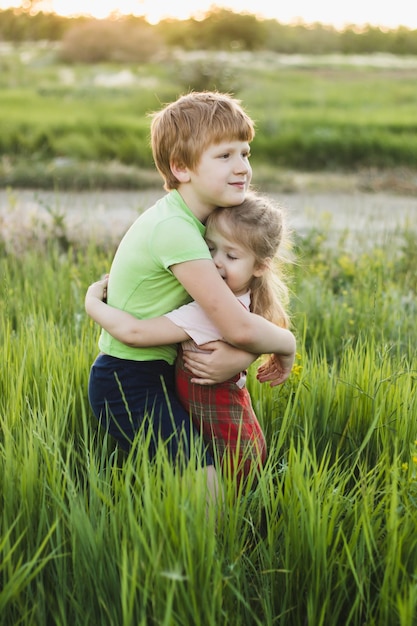 Foto um menino e uma menina se abraçando em um campo