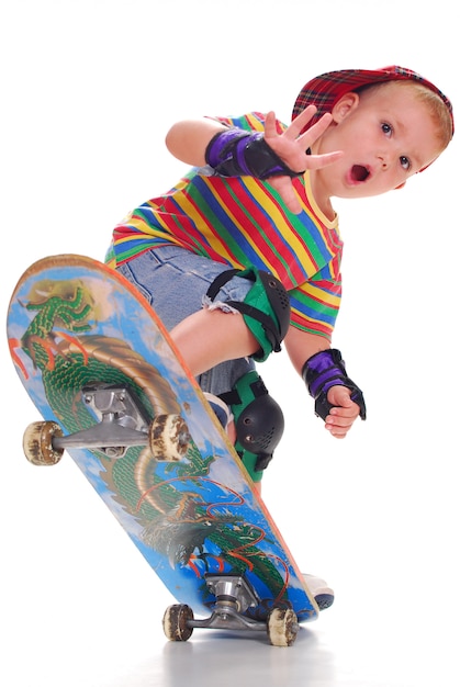 Foto um menino em roupas brilhantes em um skate empurra para cima.