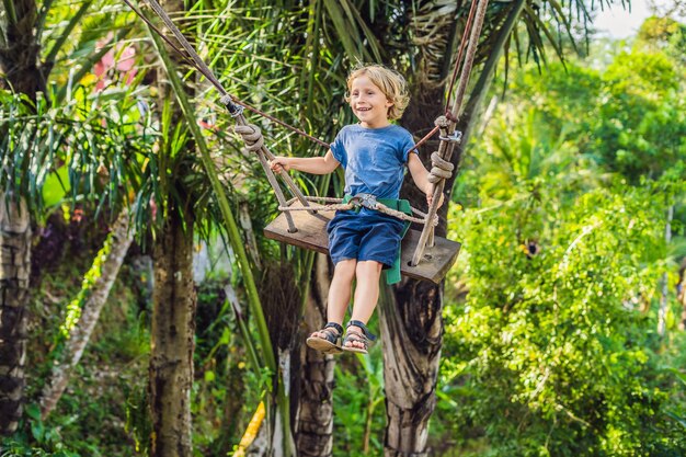 Um menino em um balanço sobre a selva, Bali.