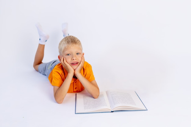Um menino em um fundo branco e isolado lendo um livro